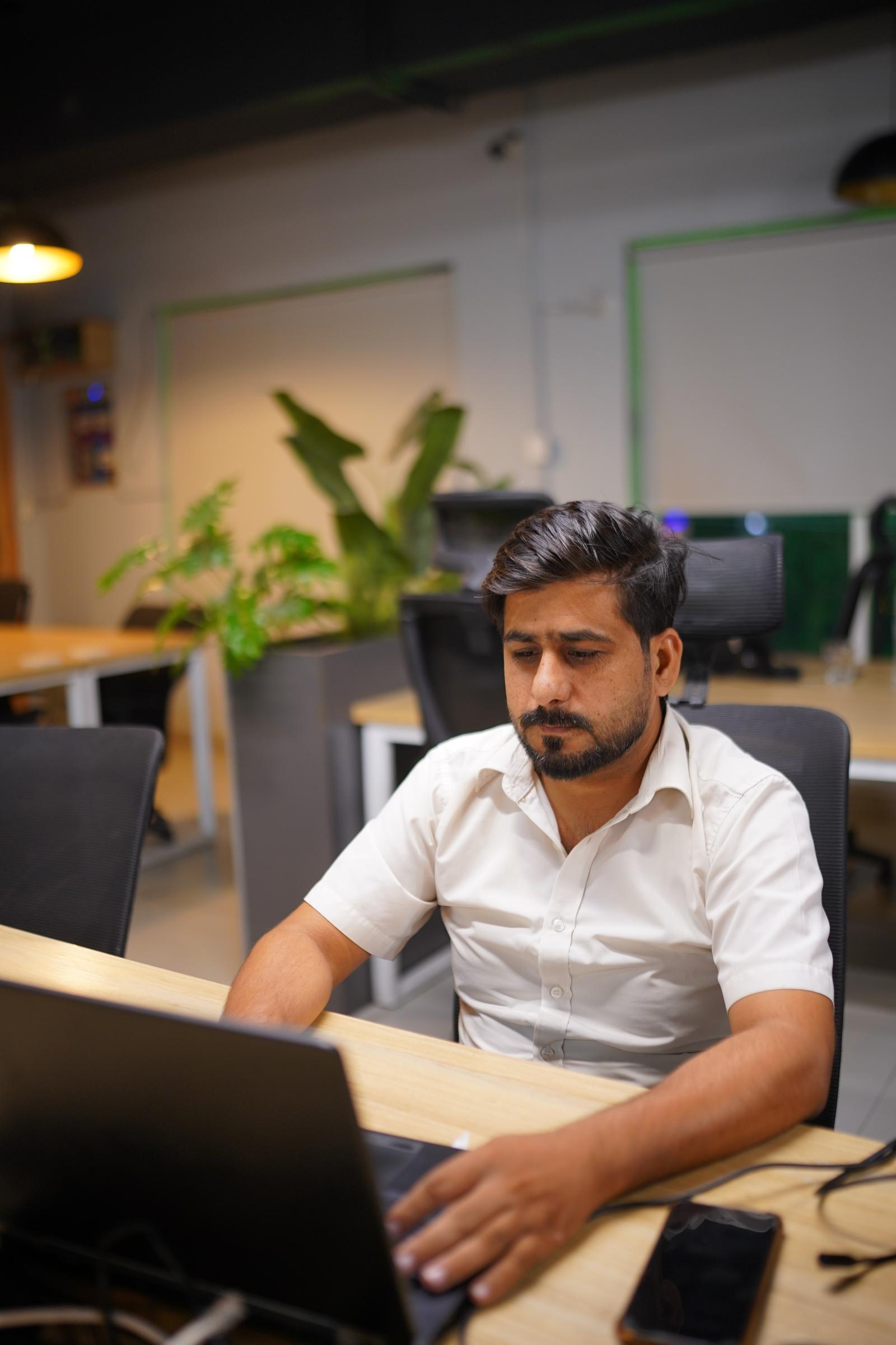 A WorkX member focused on laptop work at a desk on the coworking floor